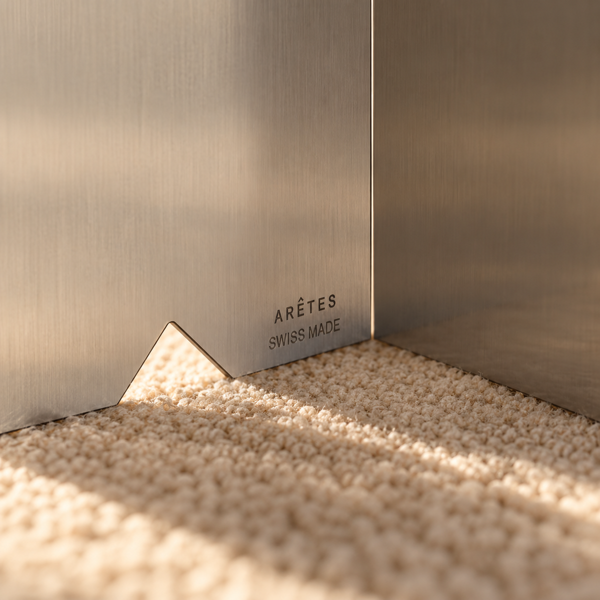 Close-up of stainless steel TA01 table with the engraved ARÊTES Swiss Made mark
